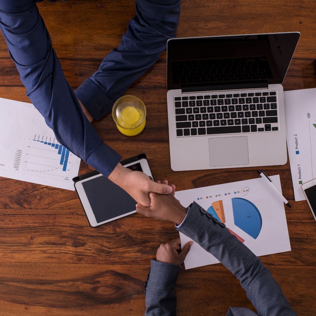 Qué es un Growth Partner - Dos personas dándose la mano en una mesa de trabajo